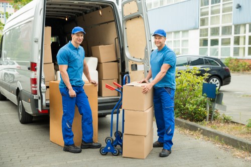 Removal team handling furniture during a home move in Palmers Green