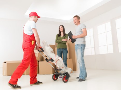 Removal team carrying furniture through a residential property in Palmers Green